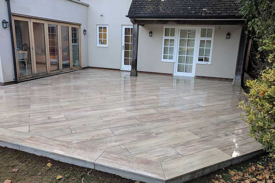 A wood effect porcelain tiled patio by AWBS Landscaping